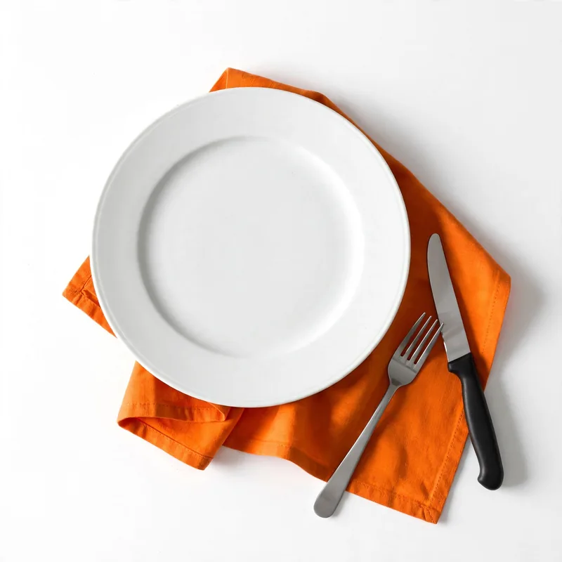 An empty dinner plate with a fork and knife